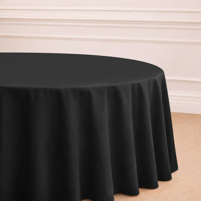 Black round tablecloth draped elegantly over a table in a bright interior setting.