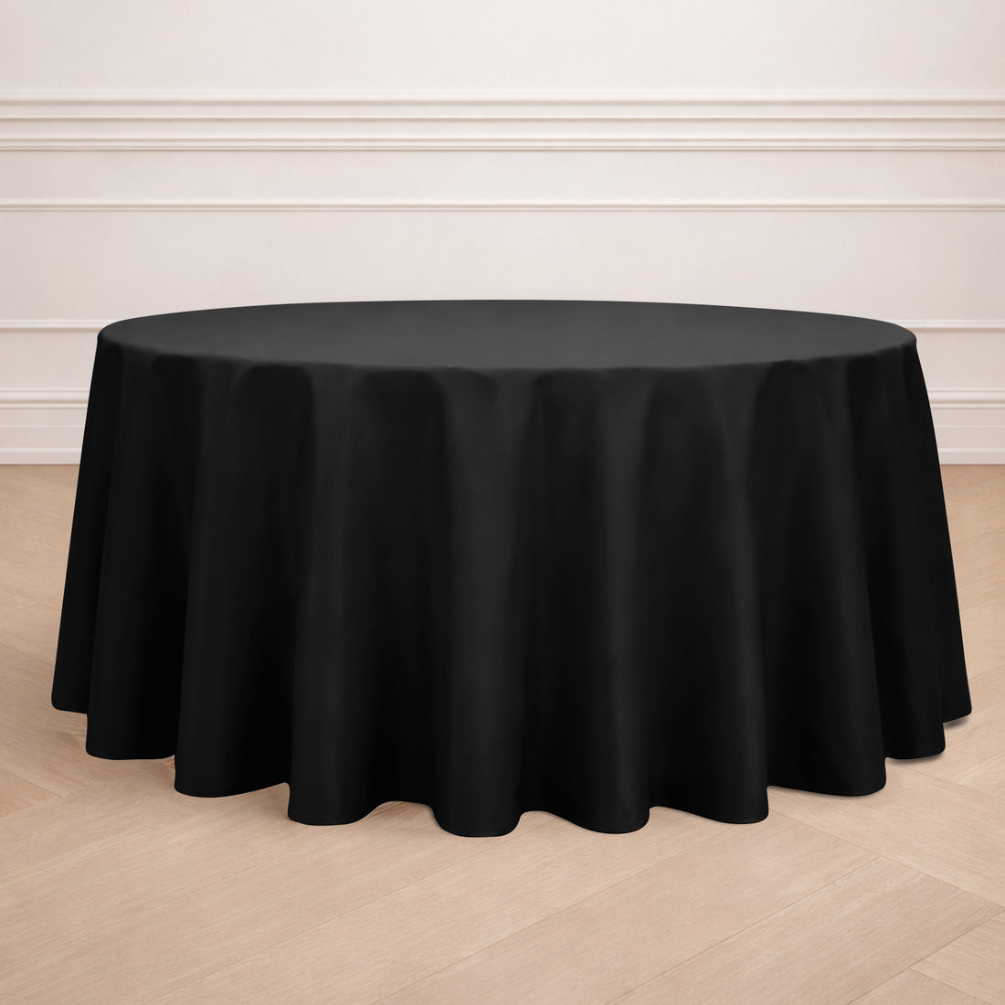 Black round tablecloth on a wooden floor.