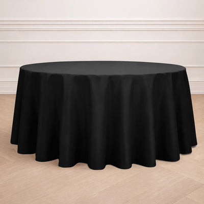 Black round tablecloth on a wooden floor.