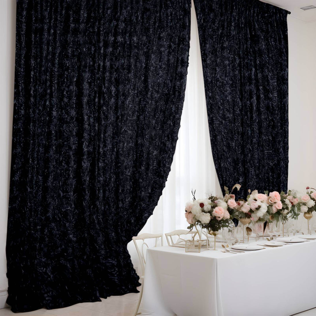 Black textured curtains draping a bright dining setup with floral centerpieces.
