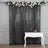 Black sequin curtain with floral garland above a white console table.