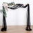 Black sheer fabric draped arch with floral accents for events and decorations.