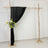 Black drapery backdrop with floral arrangement on a rustic wooden frame.