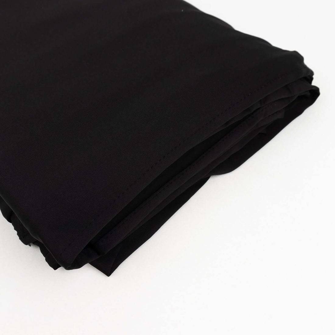 Black fabric rolled neatly on a white background
