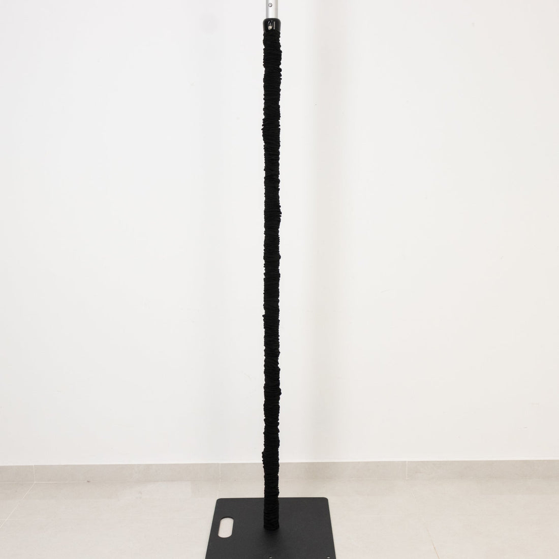 Black scratching post with a sturdy base, ideal for cats.