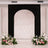 Elegant black wedding arch with floral arrangements on either side.