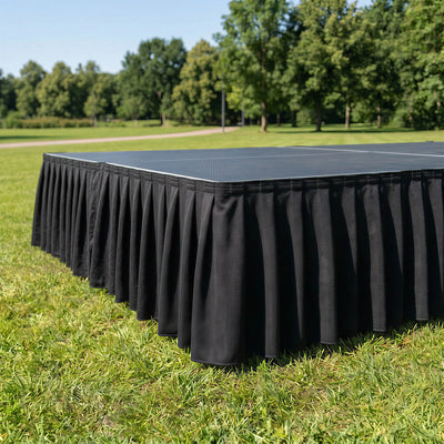 Black stage skirt on outdoor event stage in a park