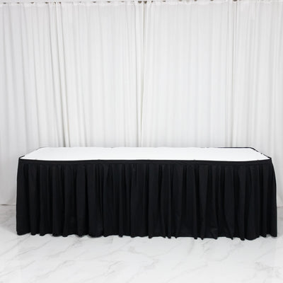 Black table skirt with white tabletop in elegant event setup, on white backdrop