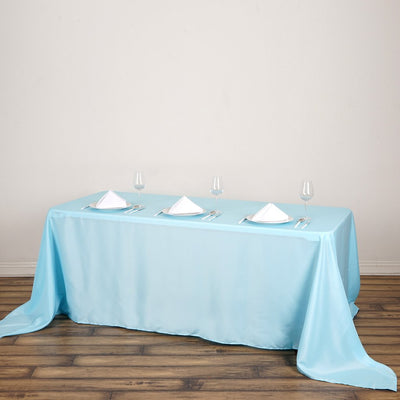 Blue tablecloth with white napkins and glassware set for dining.