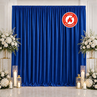 Blue flame retardant curtain wedding backdrop with white floral arrangements and candles