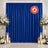 Blue flame retardant curtain wedding backdrop with white floral arrangements and candles