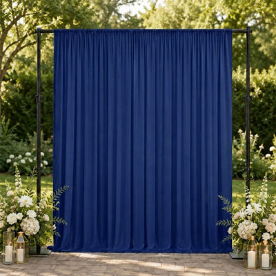 Blue outdoor wedding backdrop with floral arrangements and candle lanterns