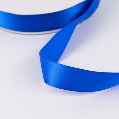 Blue satin ribbon on white background close-up