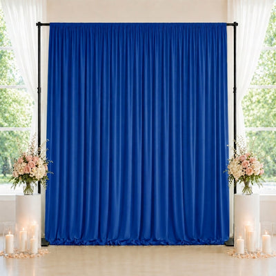 Blue wedding backdrop curtain with floral arrangements and candles