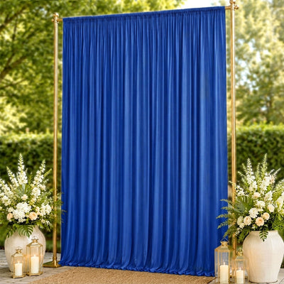 Blue wedding backdrop curtain with gold stand and floral arrangements