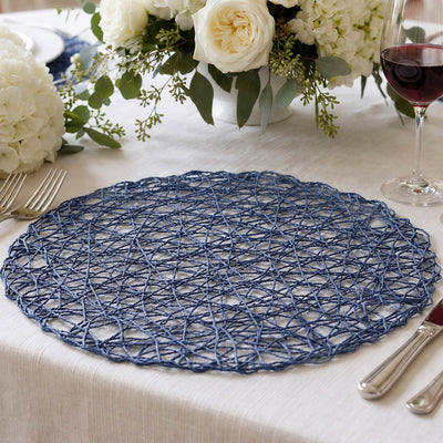 Blue woven placemat on elegant dining table with floral centerpiece and wine glass