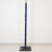 Blue wrapped pole on a black base against a white wall