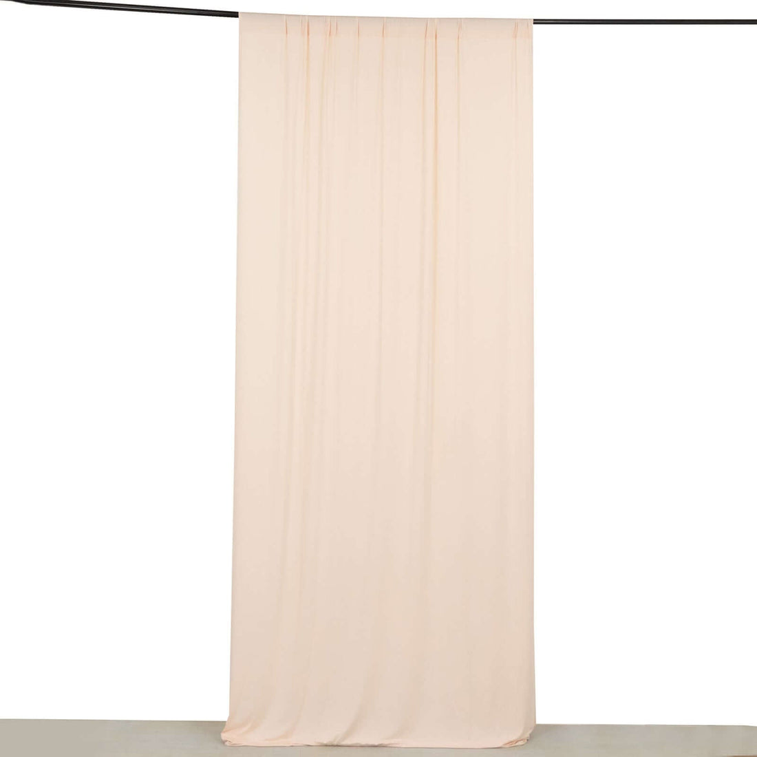 Peach fabric backdrop hanging from a rod