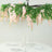 Pink floral chandelier decoration hanging above a dining table setting.