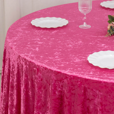 Bright pink velvet round tablecloth with white plates and glassware