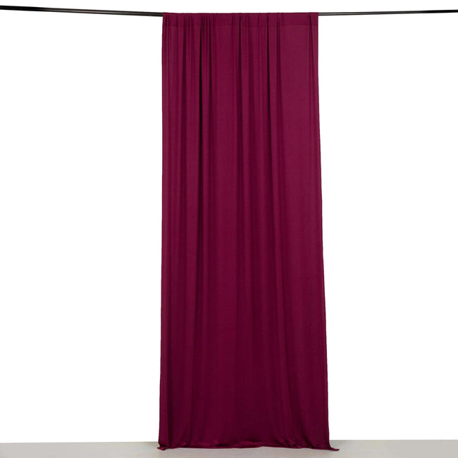 Maroon fabric curtain hanging from a rod against a white background