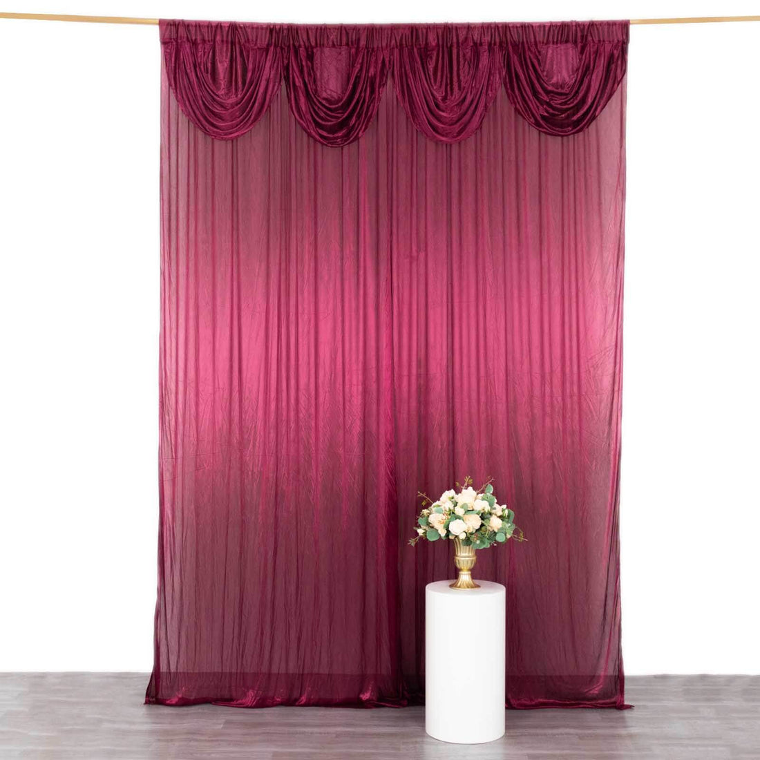 Burgundy draped fabric backdrop with pleats, styled for photography.