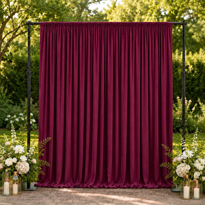 Burgundy wedding curtain backdrop with floral arrangements and lanterns outdoors