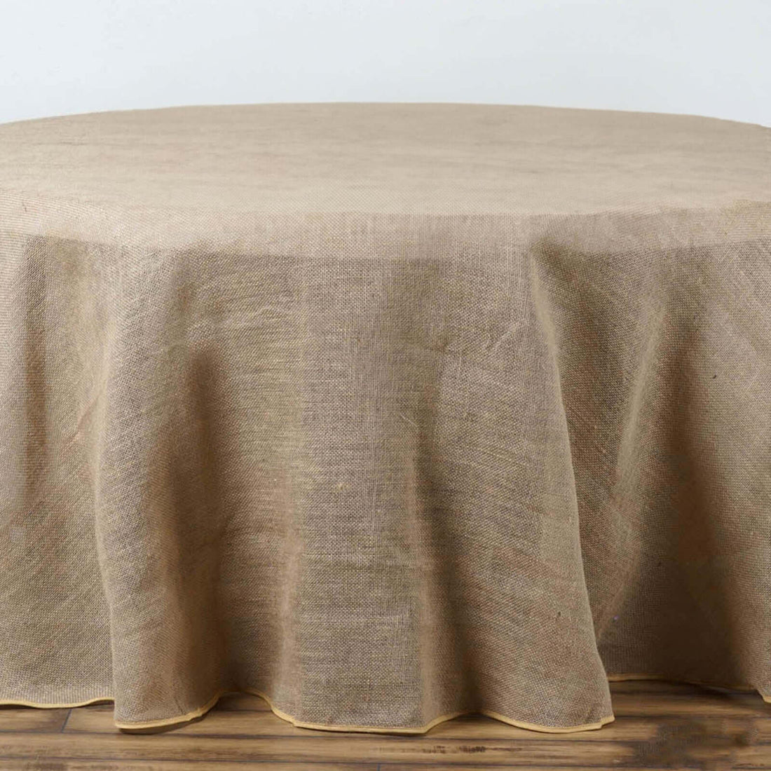 Round burlap tablecloth with a scalloped edge.