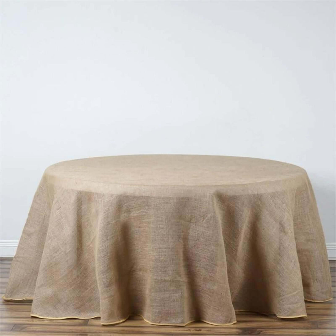 Round burlap tablecloth with elegant hem, perfect for rustic decor.