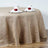 Burlap tablecloth draped over a round table with elegant napkin decor.