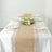 Elegant dining table setting with floral centerpiece and rustic burlap runner.