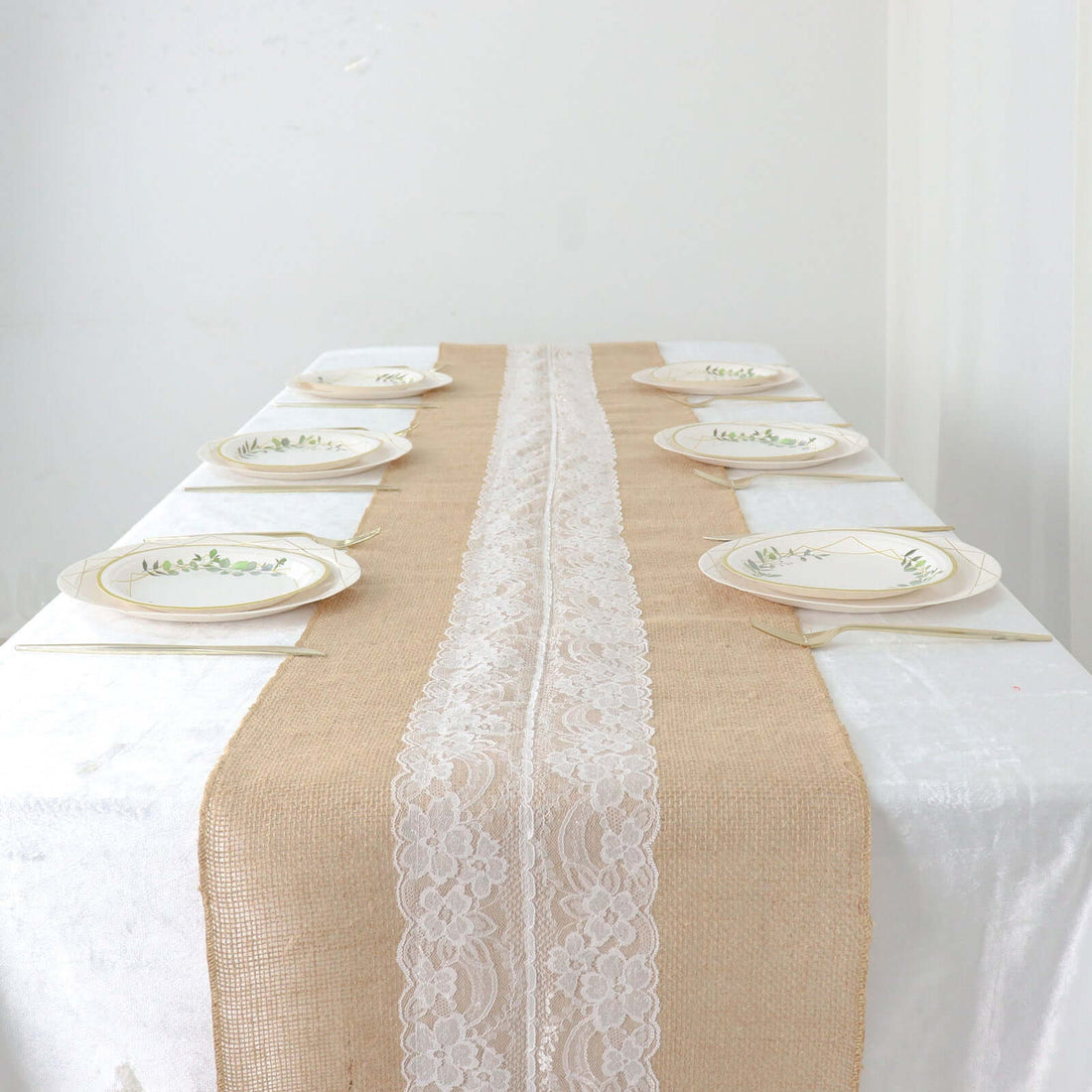 Elegant table setting with rustic burlap runner and decorative plates.