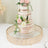 Elegant three-tiered wedding cake adorned with fresh flowers on a decorative gold tray.