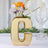 Gold letter "G" vase with flowers, stylish home decor accent.