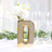Gold letter "D" vase with white flowers and glasses in a bright setting.