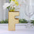 Gold letter "F" vase with flowers, elegantly styled on a table.
