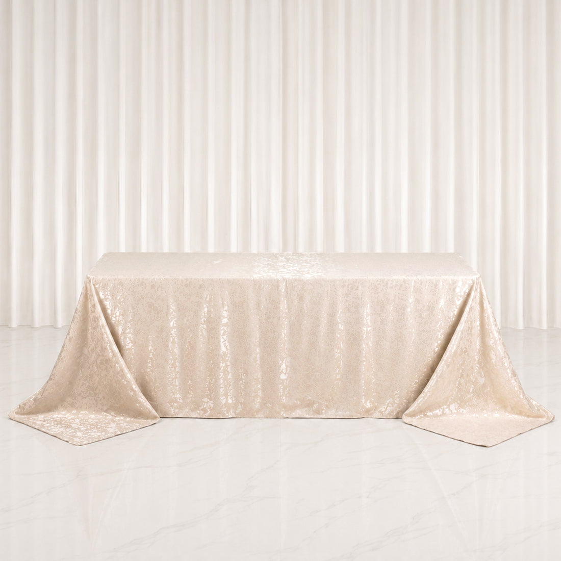Champagne gold satin tablecloth with elegant draped corners on table