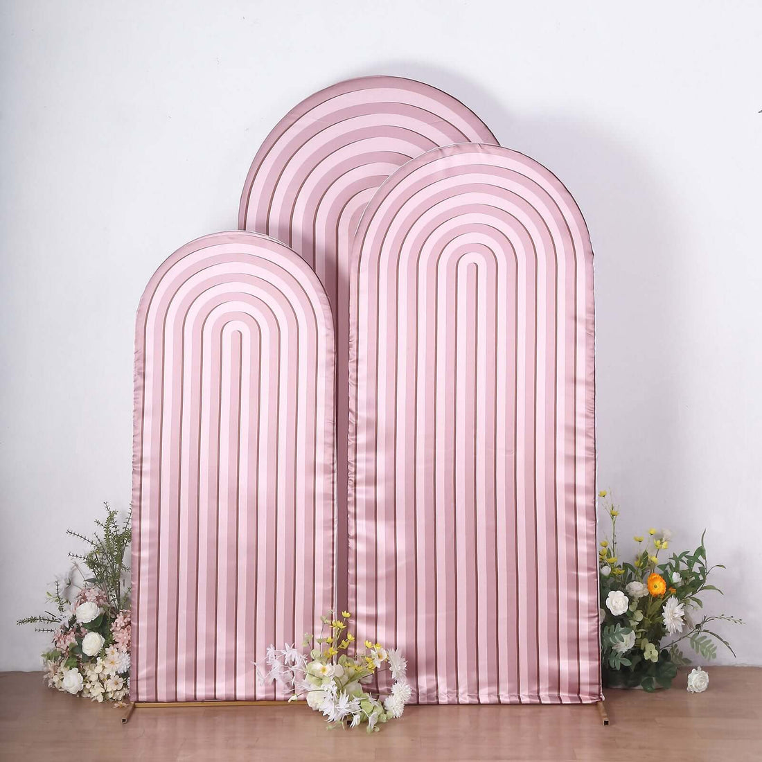 Pink arch backdrop with stripes and floral accents.
