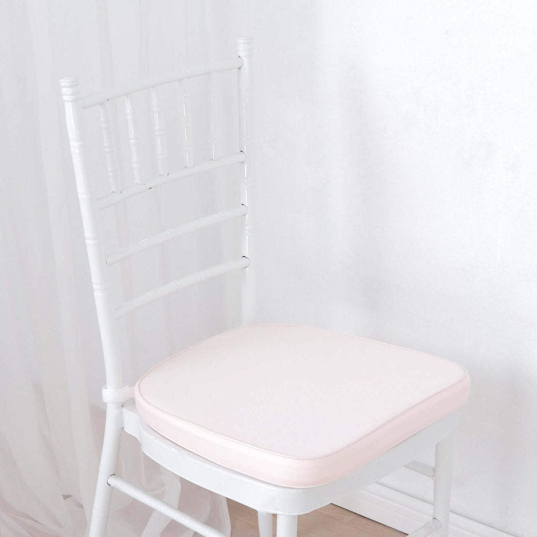 White chiavari chair with a soft pink cushion