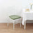 White chiavari chair with a green cushion beside a table with desserts.