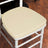 Beige chair cushion on a white wooden chair.