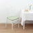 White chiavari chair with mint green cushion beside a table.