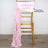 Pink satin chair sash draped on a gold chiavari chair.