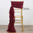 Gold chiavari chair with burgundy satin sash draped on the back.