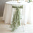 Green chiffon chair sash draped elegantly on a white chair.