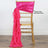 Gold chiavari chair with pink satin sash draped elegantly on back.
