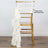 Gold chiavari chair with white satin sash draped on the back.