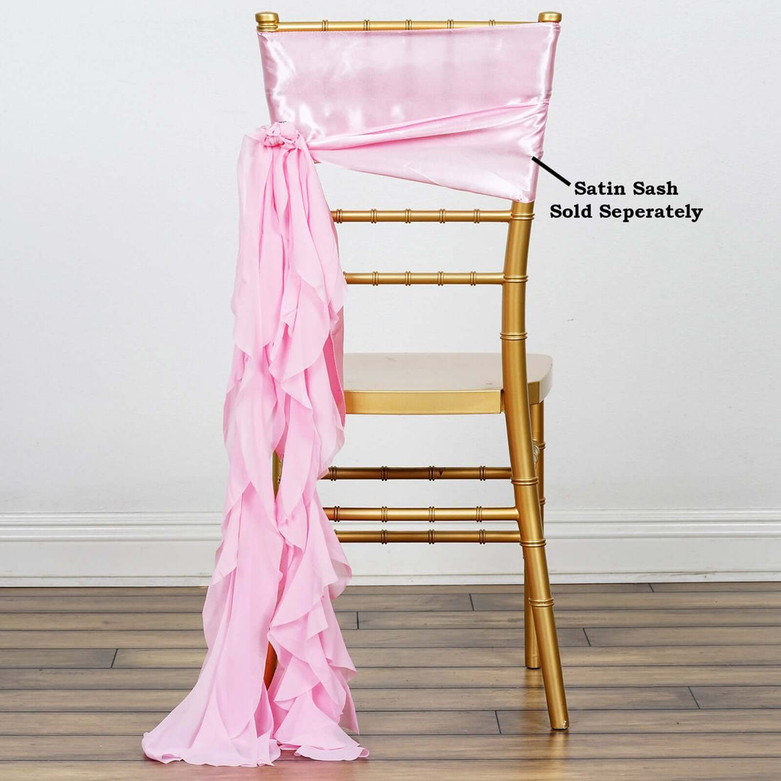 Gold chiavari chair with pink satin sash draped elegantly.