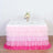 Pink ombre ruffled table skirt with a floral centerpiece and glassware.