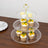 Three-tiered dessert stand with cupcakes and macarons.